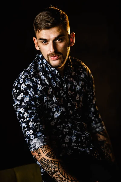 Stüdyoda poz veren genç yakışıklı adam.