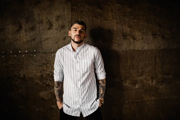 Stüdyoda poz veren genç yakışıklı adam.