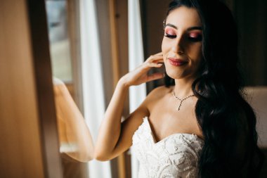 İçeride poz veren mutlu, genç gelin.