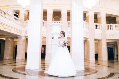 Çiçeklerle poz veren mutlu güzel gelin