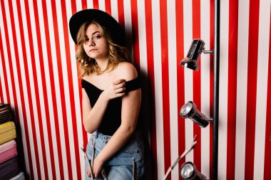 Stüdyoda poz veren şapkalı güzel bir kadın.