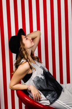 Stüdyoda poz veren şapkalı güzel bir kadın.