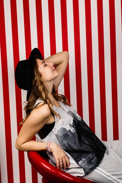 Stüdyoda poz veren şapkalı güzel bir kadın.