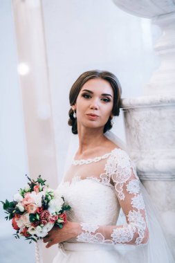 Çiçeklerle poz veren mutlu güzel gelin