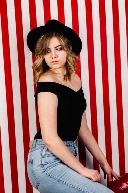 Stüdyoda poz veren şapkalı güzel bir kadın.