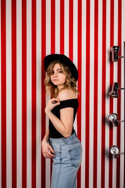 Stüdyoda poz veren şapkalı güzel bir kadın.