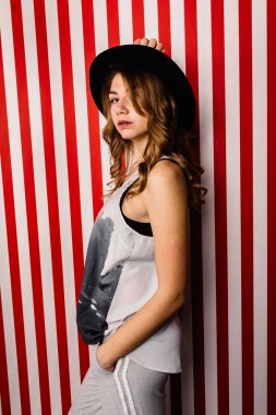 Stüdyoda poz veren şapkalı güzel bir kadın.