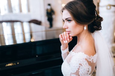 mutlu güzel genç gelin piyano tarafından poz