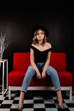 Genç güzel kadın kanepede oturan poz