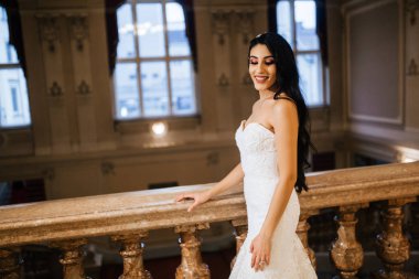 İçeride poz veren mutlu, genç gelin.