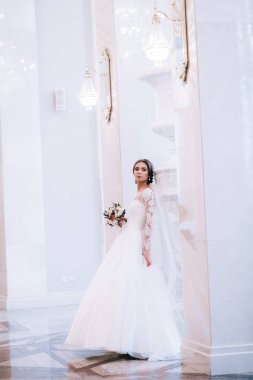 Çiçeklerle poz veren mutlu güzel gelin