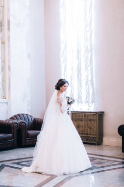 Çiçeklerle poz veren mutlu güzel gelin