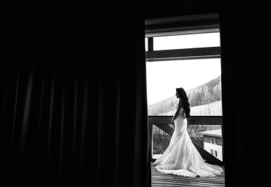 Terasta poz veren mutlu, genç bir gelin  