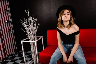 Genç güzel kadın kanepede oturan poz