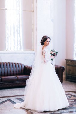 Çiçeklerle poz veren mutlu güzel gelin