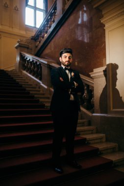 Genç yakışıklı damat içeride poz veriyor.