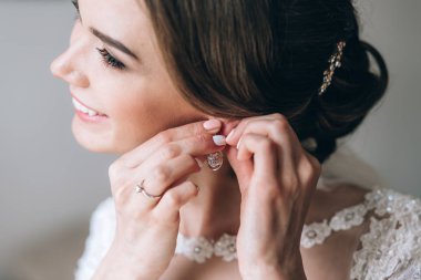 mutlu güzel genç gelin küpe üzerinde koyarak