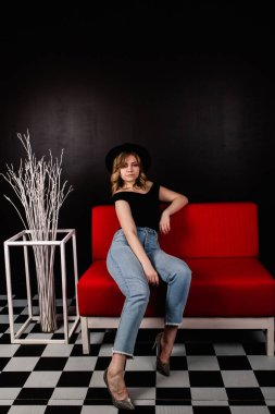 Genç güzel kadın kanepede oturan poz