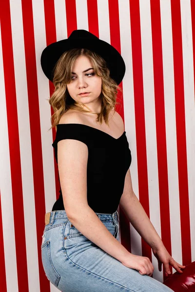 Stüdyoda poz veren şapkalı güzel bir kadın.