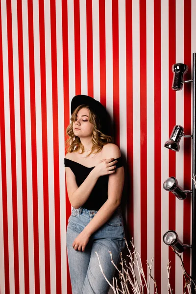 Stüdyoda poz veren şapkalı güzel bir kadın.