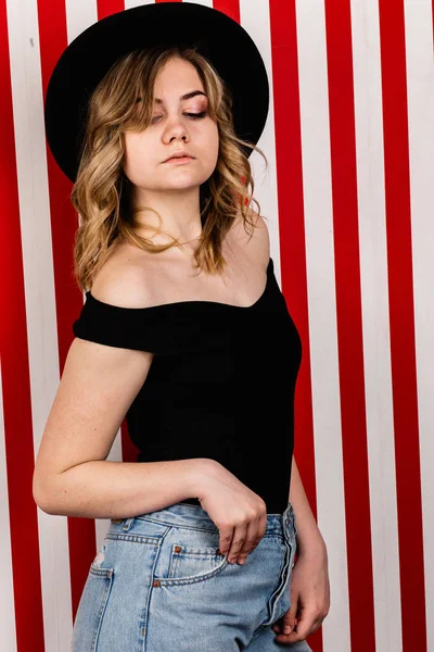 Stüdyoda poz veren şapkalı güzel bir kadın.