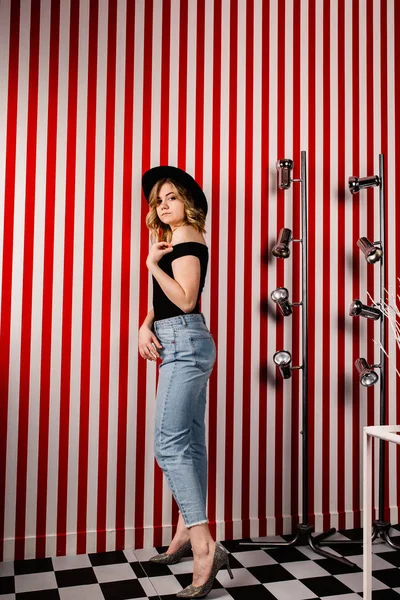 Stüdyoda poz veren şapkalı güzel bir kadın.