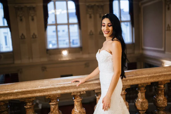 İçeride poz veren mutlu, genç gelin.