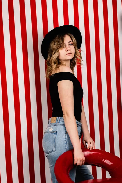 Stüdyoda poz veren şapkalı güzel bir kadın.