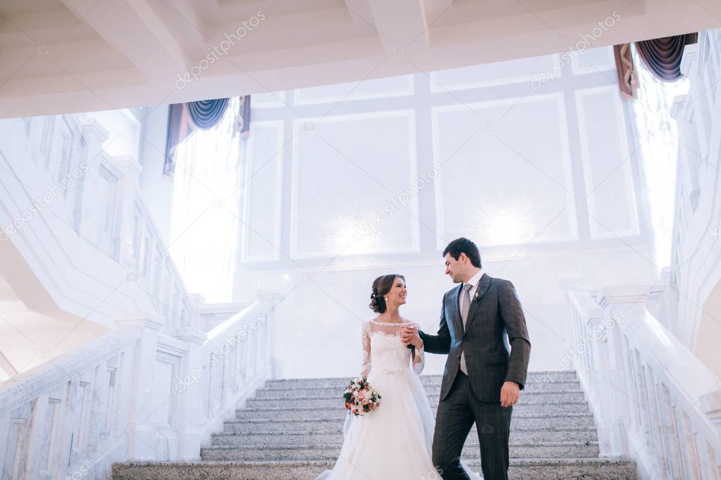happy young  beautiful  couple of newlyweds on staircase