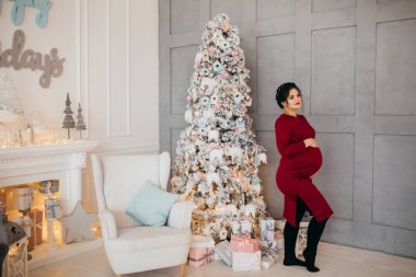 mutlu güzel hamile kadın Noel ağacı tarafından poz