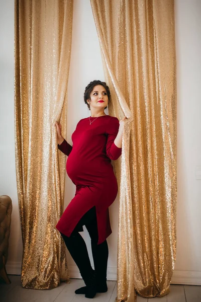 Mutlu güzel hamile kadın evde poz veriyor.