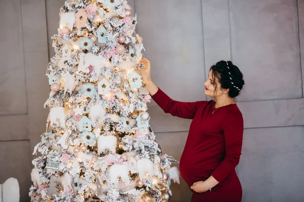 Ευτυχής Όμορφη Έγκυος Γυναίκα Που Παρουσιάζουν Από Χριστουγεννιάτικο Δέντρο — Φωτογραφία Αρχείου