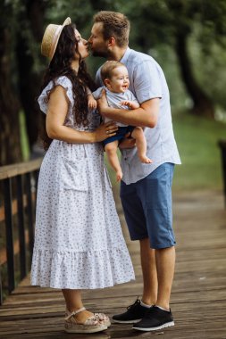Parkta küçük bir oğlu olan mutlu genç bir aile.