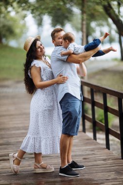 Parkta küçük bir oğlu olan mutlu genç bir aile.