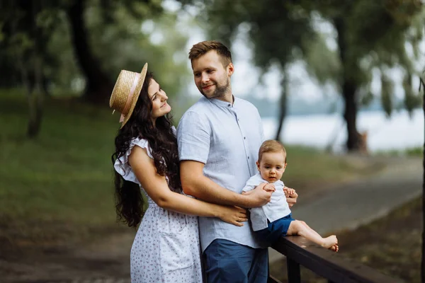 Parkta küçük bir oğlu olan mutlu genç bir aile.