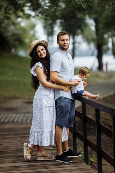 Parkta küçük bir oğlu olan mutlu genç bir aile.