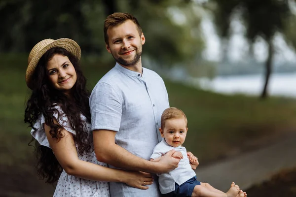 Parkta küçük bir oğlu olan mutlu genç bir aile.