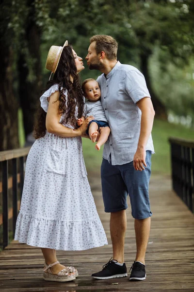 Parkta küçük bir oğlu olan mutlu genç bir aile.