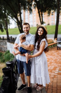 Parkta küçük bir oğlu olan mutlu genç bir aile.