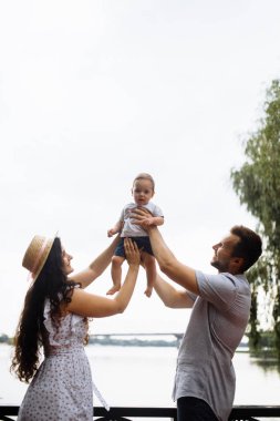 Parkta küçük bir oğlu olan mutlu genç bir aile.