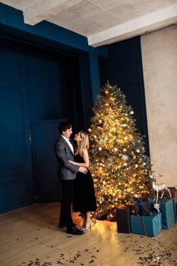 Harika evli çift Noel ağacının yanında poz veriyor.