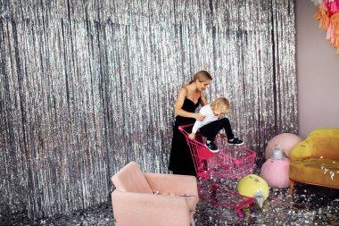 Mutlu genç anne ve oğlu alışveriş arabasında eğleniyorlar. 