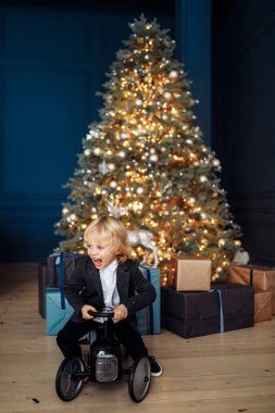 Mutlu sevimli çocuk oyuncak arabanın yakınında ağaç üzerinde