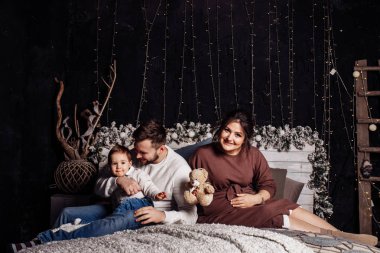 Mutlu genç aile yatağa poz