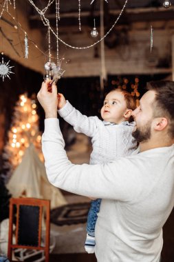 Mutlu genç baba oğluyla Noel dekorasyon arıyorsunuz 