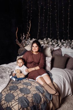 Mutlu anne ve oğul yatakta poz veriyor. 