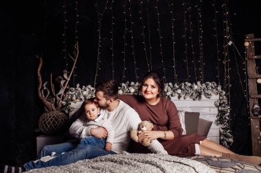 Mutlu genç aile yatağa poz