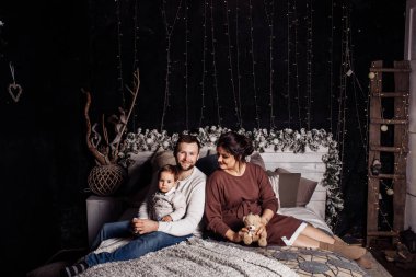 Mutlu genç aile yatağa poz