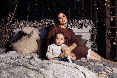 Mutlu anne ve oğul yatakta poz veriyor. 