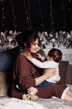 Mutlu anne ve oğul yatakta poz veriyor. 